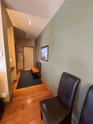 a hallway with two chairs and a table and a door at Magical Views at Southpoint Big White! Best Location! in Big White