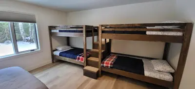 two bunk beds in a room with a window at Fernie Escape - Mountain Home on the Ski Hill in Fernie