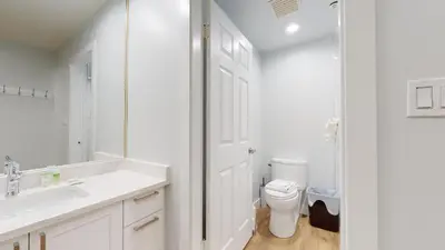 a white bathroom with a sink and a toilet at Ironwoods on Blueberry Hill by Whistler Blackcomb Vacation Rentals in Whistler