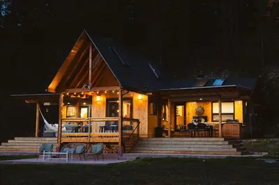 a large wooden house with a porch and stairs at The Kootenay Lake House - A Private Luxury Retreat in Nakusp