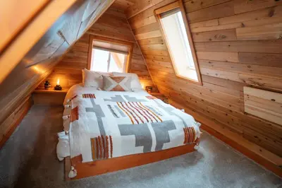 a bedroom with a bed in a wooden cabin at The Kootenay Lake House - A Private Luxury Retreat in Nakusp