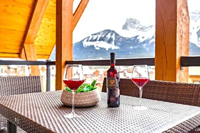 a bottle of wine sitting on a table with two glasses at Luxury Penthouse At Solar A Resort And Spa in Canmore