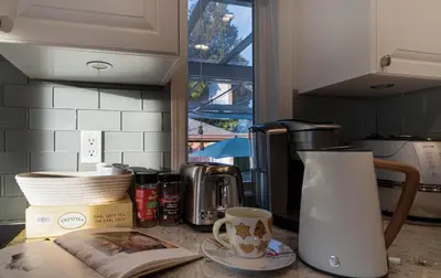 a kitchen counter with a book and a cup of coffee at \u6e29\u897f\u533a\u8c6a\u534e\u522b\u5885\u9644\u6709\u6309\u6469\u6d74\u7f38\u94a2\u7434\uff0c\u63a5\u8fd1\u673a\u573adowntown in Vancouver
