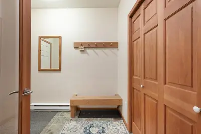 a door with a wooden bench next to a mirror at Deer Run by Whistler Premier in Whistler