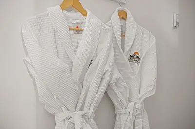two white sweaters are hanging on a wall at Attractive Downtown Condo! Hot Tub, Mountain Views managed by Little Sister Getaways in Canmore