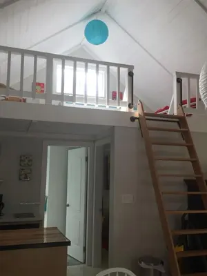 a staircase in a room with a loft at Cozy ,artistic cottage in a garden setting close to the beach and hiking trails. in Powell River