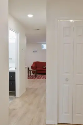 a hallway with a white door and a red couch at NN - The Névé - Crestview 1-bed 1-bath in Whitehorse
