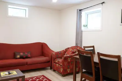 a living room with a red couch and a table at NN - The Névé - Crestview 1-bed 1-bath in Whitehorse
