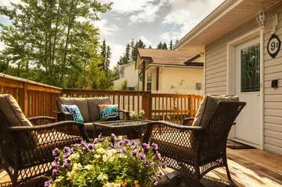 a patio with three chairs and a table and flowers at NN - The Summit - Copper Ridge 1-bed 1-bath in Whitehorse