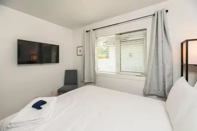 a white bedroom with a bed and a window at NN - The Summit - Copper Ridge 1-bed 1-bath in Whitehorse