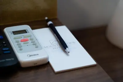 a pen sitting on top of a book next to a remote control at Mountain View Hope Motel in Hope