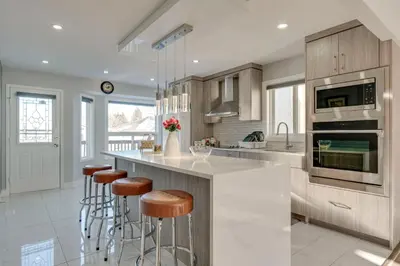 a kitchen with a island with bar stools at Rare Find fully renovated 6 bedroom 3 bath and both levels in Calgary