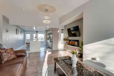 a living room with a couch and a table at Rare Find fully renovated 6 bedroom 3 bath and both levels in Calgary