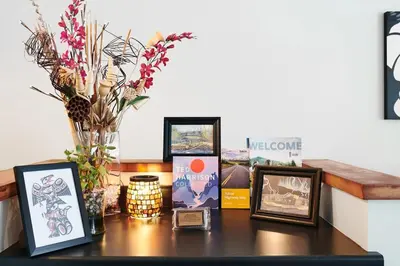 a table topped with pictures and a vase with flowers at NN - The Kit - Downtown 1-bed 1-bath in Whitehorse