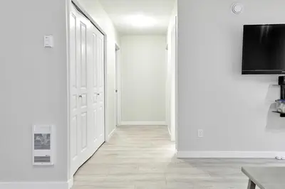 a hallway with white walls and a flat screen tv at NN - Eddy #1 - Whistlebend 3-bed 2 5-bath in Whitehorse