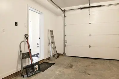 a garage with two garage doors and a ladder at NN - Eddy #1 - Whistlebend 3-bed 2 5-bath in Whitehorse