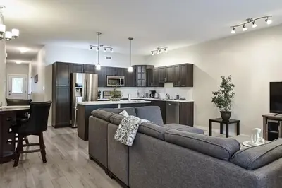 a living room with a couch and a kitchen at NN - Eddy #1 - Whistlebend 3-bed 2 5-bath in Whitehorse