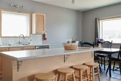 a kitchen with a large island with stools around it at NN - The Kluane - Whistlebend 3-bed 2-bath in Whitehorse