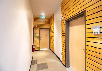 a hallway with a door in a room with wooden walls at NN - Park View #2 - Downtown 2-bed 2-bath in Whitehorse