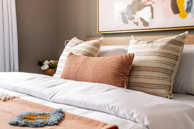 a bed with white sheets and pillows on it at Peaceful Oasis Condo, AC, Top Floor, Secure UG Parking, Balcony, King Bed! in Edmonton
