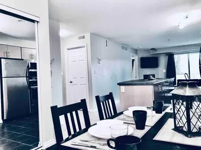 a kitchen with a table and chairs and a kitchen with a table and a table at 2 BDRM A/C Condo w/Ensuite Laundry + Free Parking in Edmonton