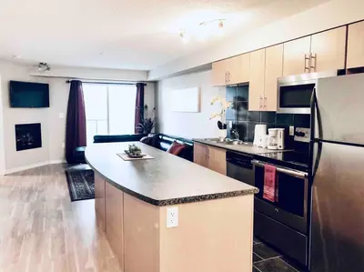 a kitchen with a counter top and a refrigerator at 2 BDRM A/C Condo w/Ensuite Laundry + Free Parking in Edmonton