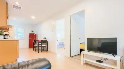a living room with a flat screen tv and a kitchen at Ocean Park B&B in Surrey
