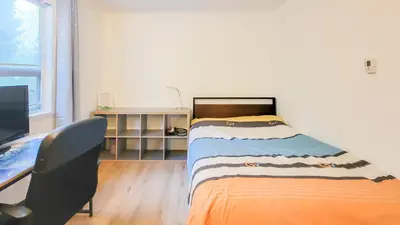 a bedroom with a bed and a desk with a computer at Ocean Park B&B in Surrey