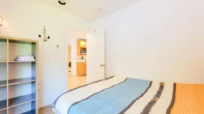 a white bedroom with a bed and a hallway at Ocean Park B&B in Surrey