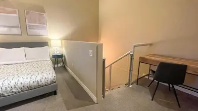 a bedroom with a bed and a desk and a table at 2BR plus Loft, Modern and Spacious, Hot Tub and Sauna, Private Balcony, Fireplace in Whistler