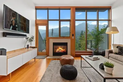 a living room with a fireplace and a couch at Whistler 'Treehouse' in Whistler