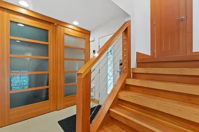 a staircase in a home with wooden doors and glass panels at Whistler 'Treehouse' in Whistler