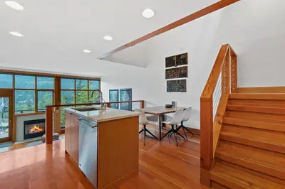 a kitchen with a staircase and a table and a fireplace at Whistler 'Treehouse' in Whistler
