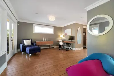 a living room with a couch and a chair and a mirror at Great West Vancouver house with hot tub, across from beach & 10 mn to Downtown Vancouver in West Vancouver