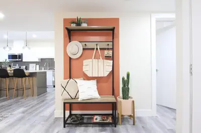 a living room with an orange accent wall at Executive Bsmt Suite, King Bed, 5 min to DT & Whyte Ave, Sleeps 6! in Edmonton