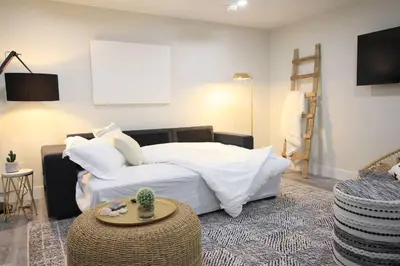 a bedroom with a white bed and a table at Executive Bsmt Suite, King Bed, 5 min to DT & Whyte Ave, Sleeps 6! in Edmonton