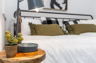 a bedroom with a bed and a table with a lamp at Chic Hideaway, 5BR near DT, Fireplace, King Bed, Fast Wifi, Sleeps 13! in Edmonton