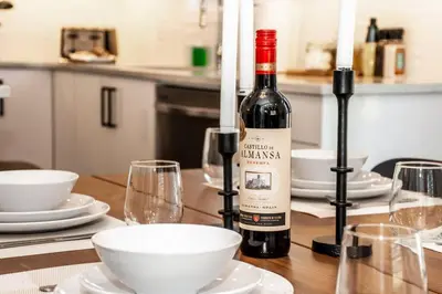 a bottle of wine sitting on a table with glasses at Nordic Retreat, 4BR, Min to WEM & DT, AirCon & Fireplace, Sleeps 10! in Edmonton