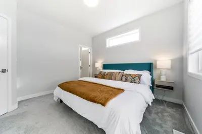 a bedroom with a large bed and a window at Nordic Retreat, 4BR, Min to WEM & DT, AirCon & Fireplace, Sleeps 10! in Edmonton