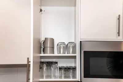 a kitchen with white cabinets and a microwave at Cozy Nordic Utopia, Bsmt Suite near WEM & DT, King Bed, WiFi in Edmonton