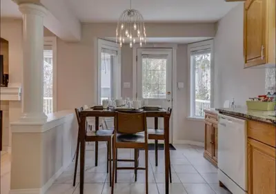 a kitchen with a table with chairs and a chandelier at Big family home w/ Deck, Ping Pong, BBQ & Garage in Edmonton