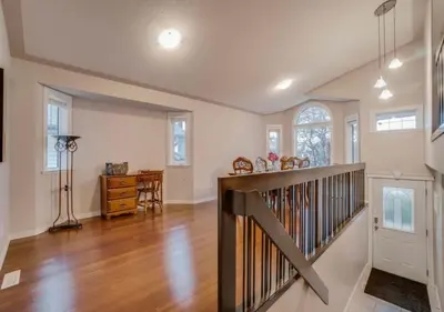 an empty living room with a wooden staircase and a hallway at Big family home w/ Deck, Ping Pong, BBQ & Garage in Edmonton