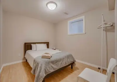 a white bedroom with a bed and a window at Big family home w/ Deck, Ping Pong, BBQ & Garage in Edmonton