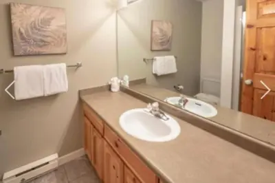 a bathroom with a sink and a mirror at Whistler Steps to Village Sleeps 8 + Jacuz + Park in Whistler