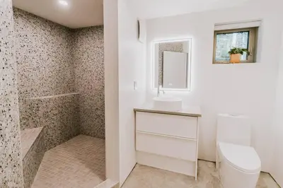 a bathroom with a toilet and a sink and a mirror at Okt Häus in Nordegg