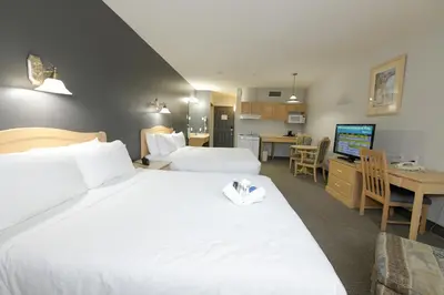a hotel room with a large bed and a kitchen at Prime Hotel in Fort McMurray