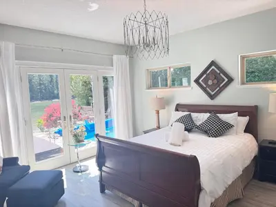 a bedroom with a large bed and a chandelier at luxury ocean dock pool villa in Ladysmith
