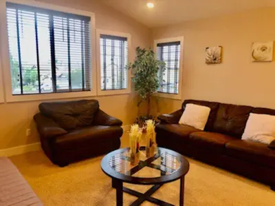 a living room with a couch and a table at Luxury 3700 sq/ 5 bedroom/ jettedtub/ 4 fireplaces in Edmonton