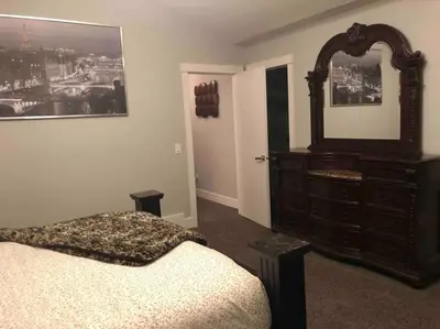 a bedroom with a dresser and a large mirror at Cheerful and beautiful 3 bedroom home close lake in Edmonton