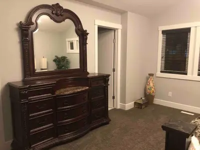 a large wooden dresser with a mirror in a room at Cheerful and beautiful 3 bedroom home close lake in Edmonton